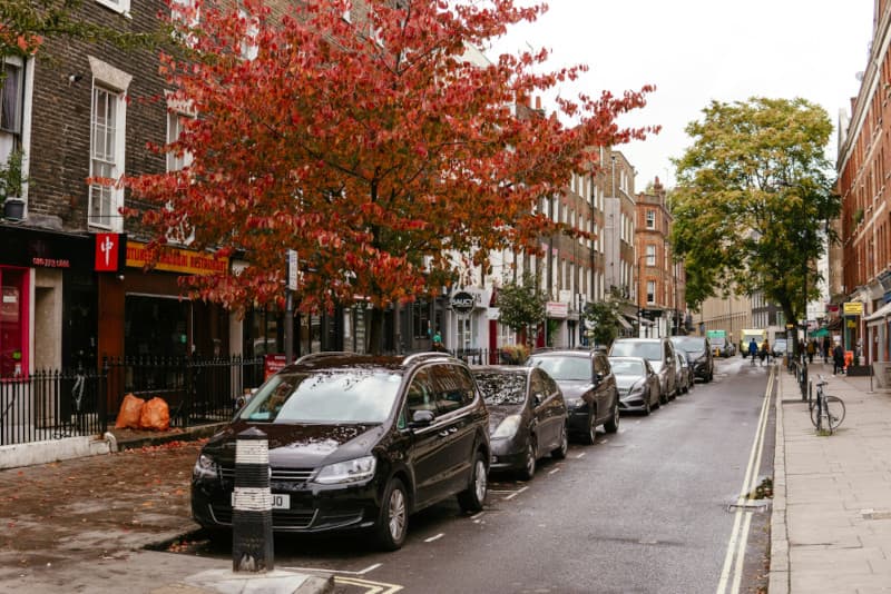 London residential street with parked cars and moving vans