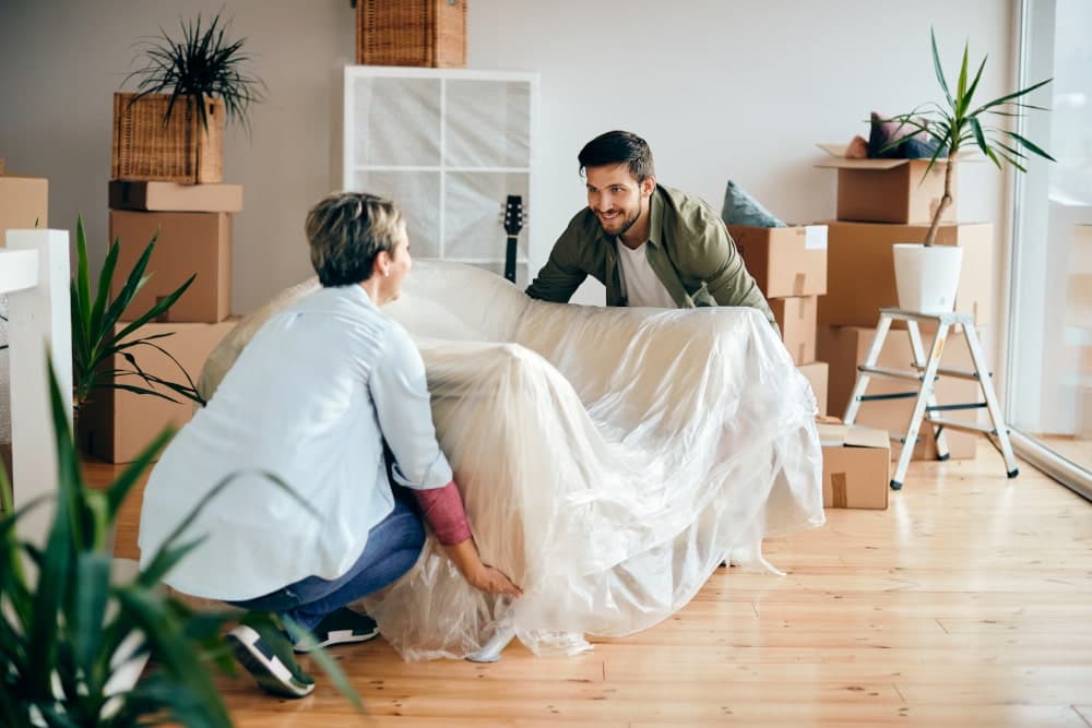 Couple moving house and moving a sofa themselves
