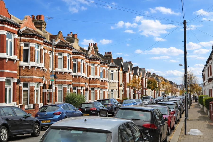 London residential street with parked cars and moving vans